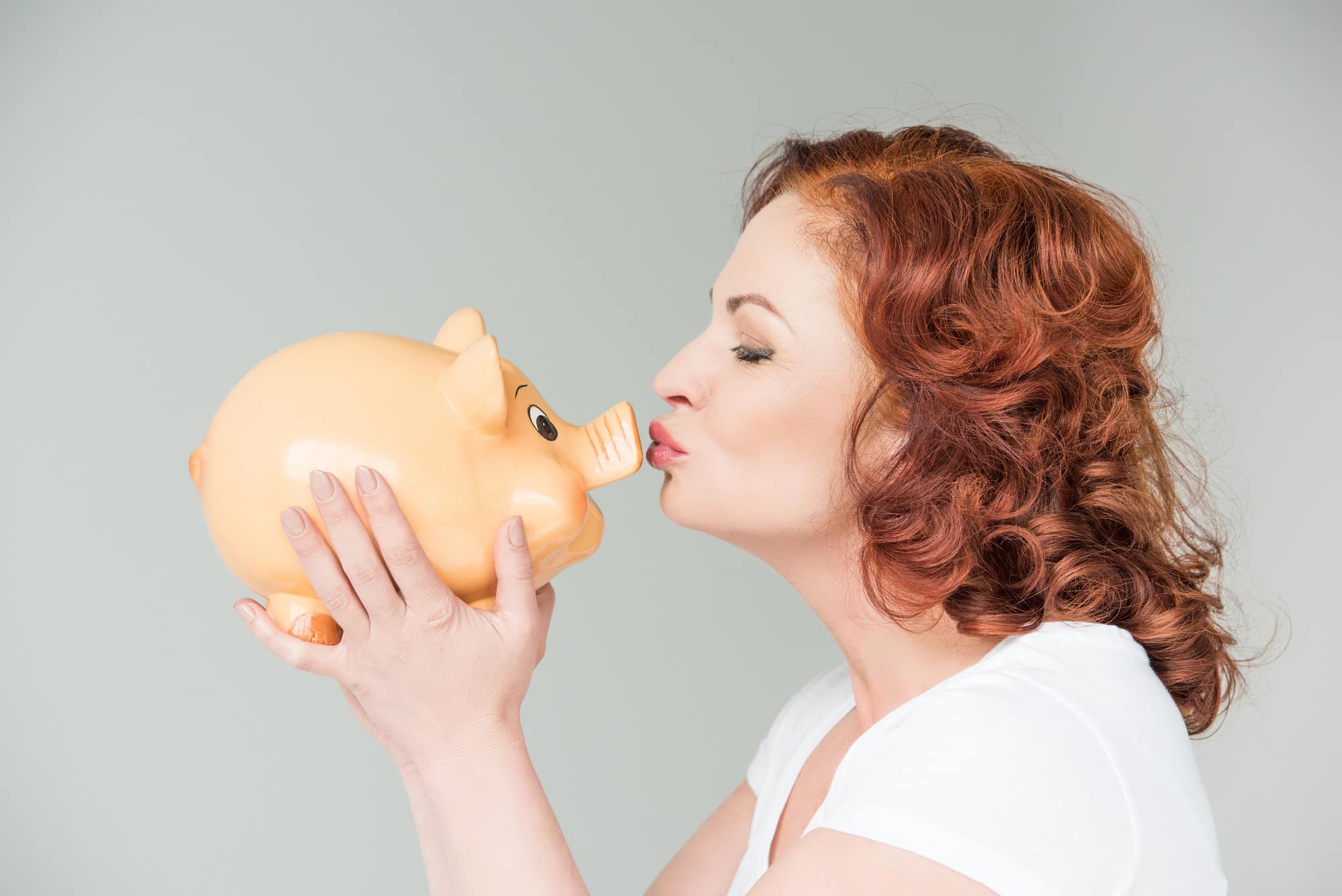 woman kissing piggy bank