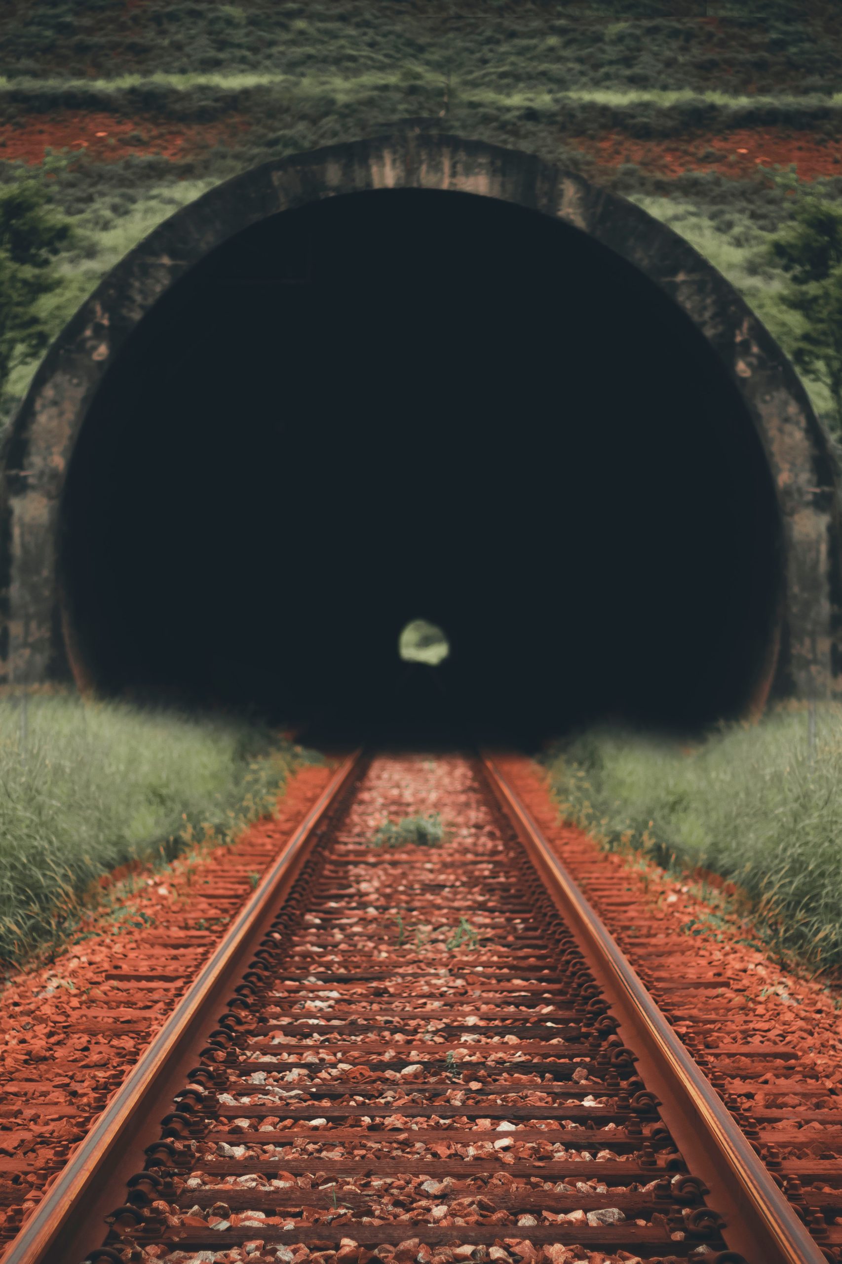 railway line disappearing into dark tunnel